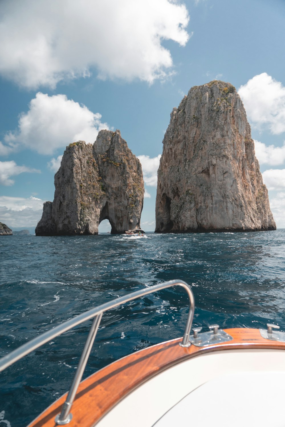 weißes und braunes Boot in Richtung Felsformation