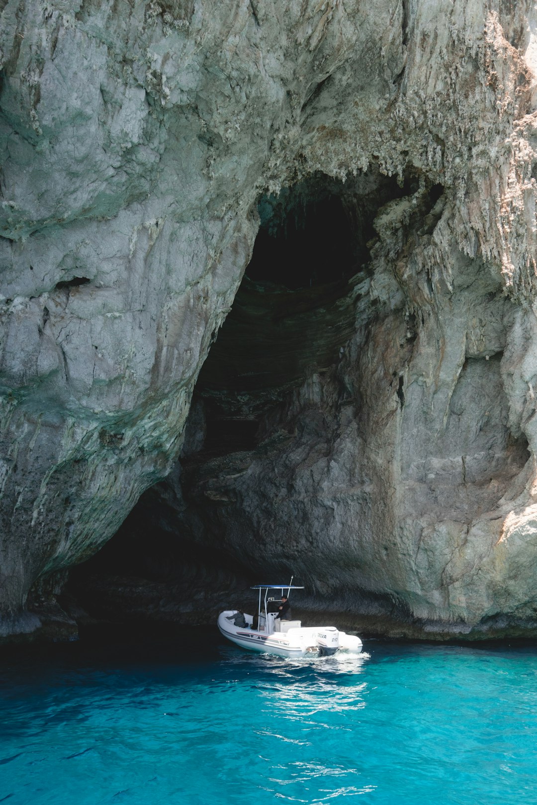 white speed boat near rock formation