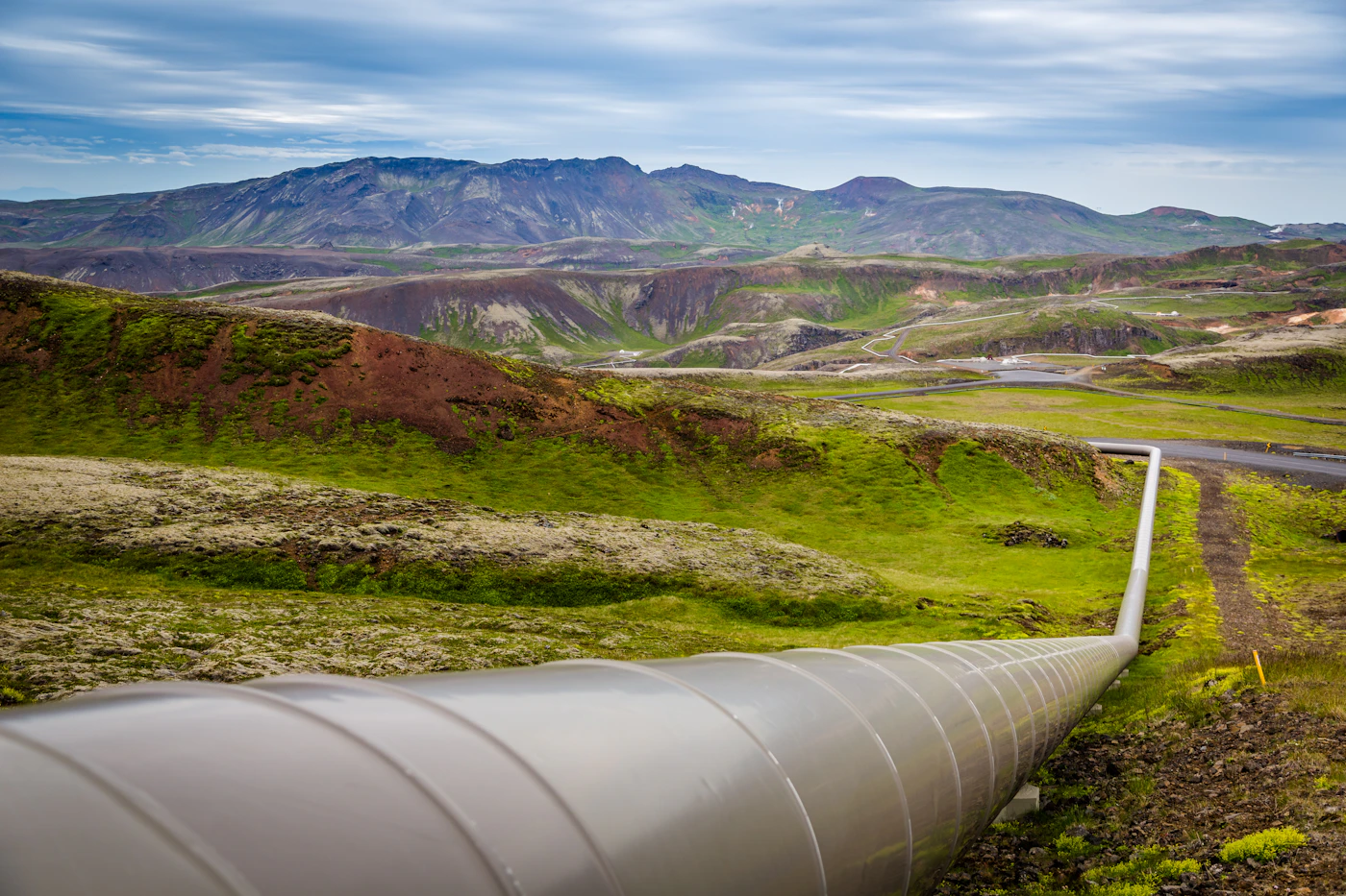 Industrial pipeline winding through mountainous terrain — power and pipeline infrastructure