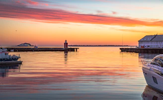 A warmly lit exterior of a cozy harbor-side property managed by j&l harbor properties llc during sunset.