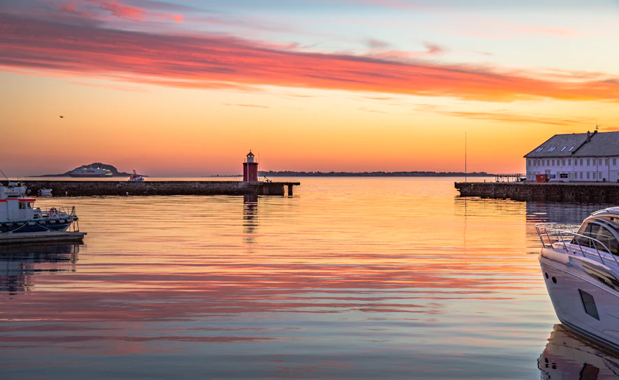 A warmly lit exterior of a cozy harbor-side property managed by j&l harbor properties llc during sunset.