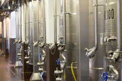 Rows of gleaming stainless steel brewing tanks inside Fruvera’s modern production facility.