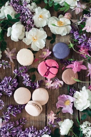 A beautifully arranged platter of colorful macarons in pastel shades on a rustic wooden table