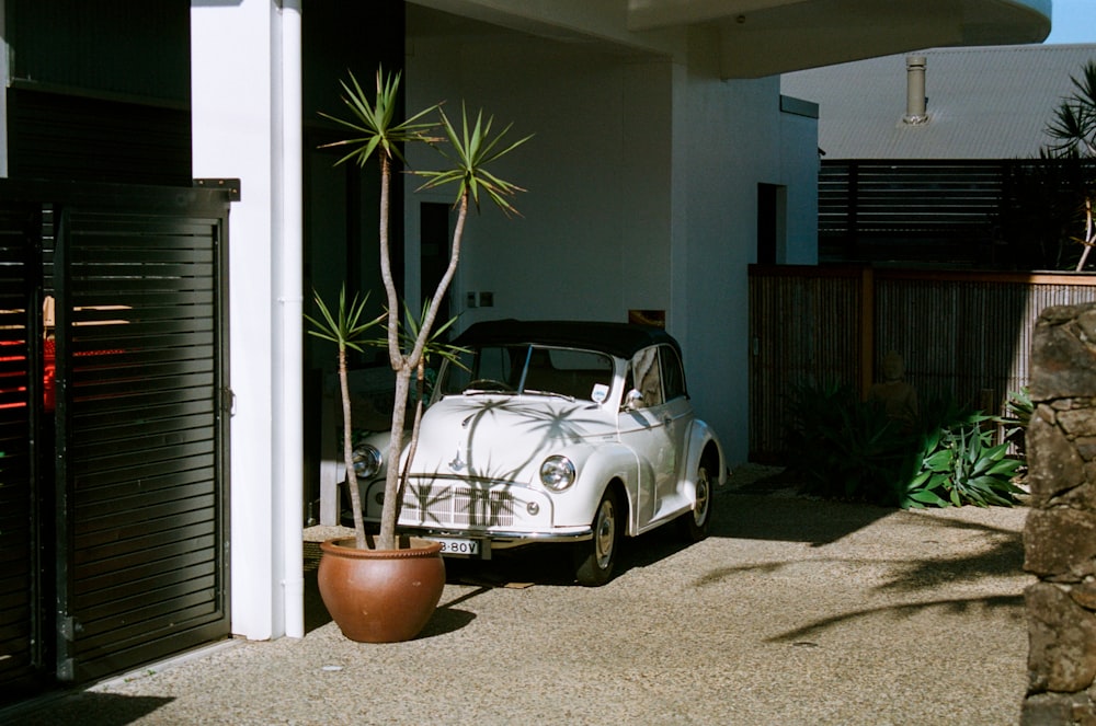 white and black Volkswagen beetle parked on a house garage