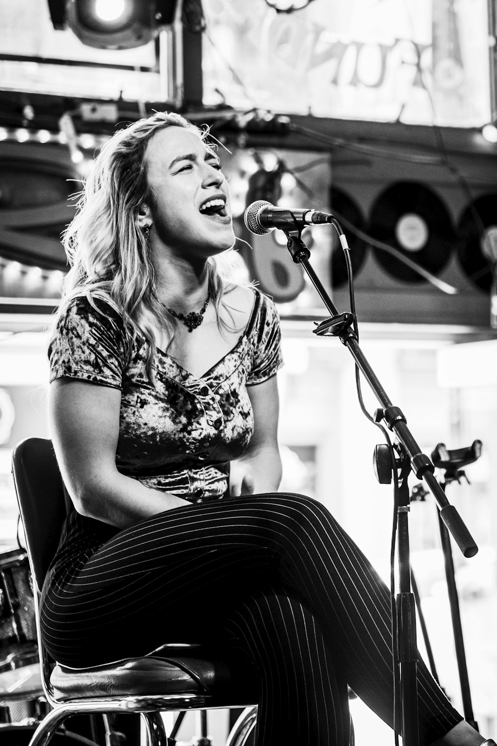 greyscale photo of woman singing inside studio