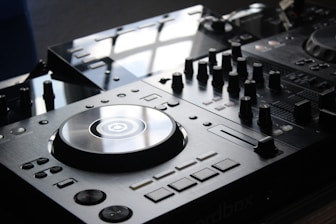 Close-up of DJ mixing music on professional equipment with sleek modern visuals.