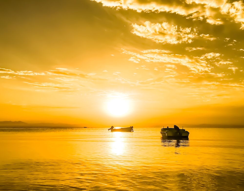 two boats on sea during sunset