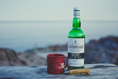 red mug beside wine bottle