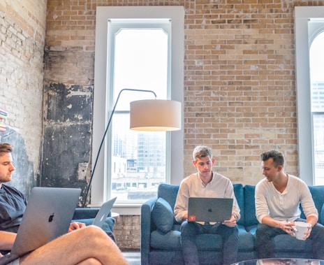 three men using MacBooks