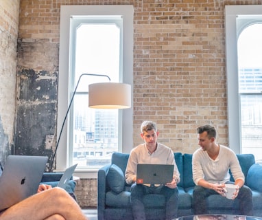 three men using MacBooks