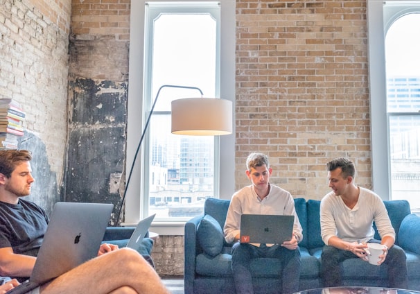 three men using MacBooks