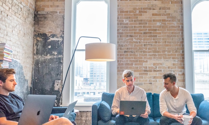 three men using MacBooks