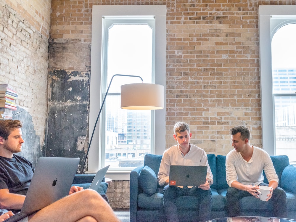 trois hommes utilisant des MacBook