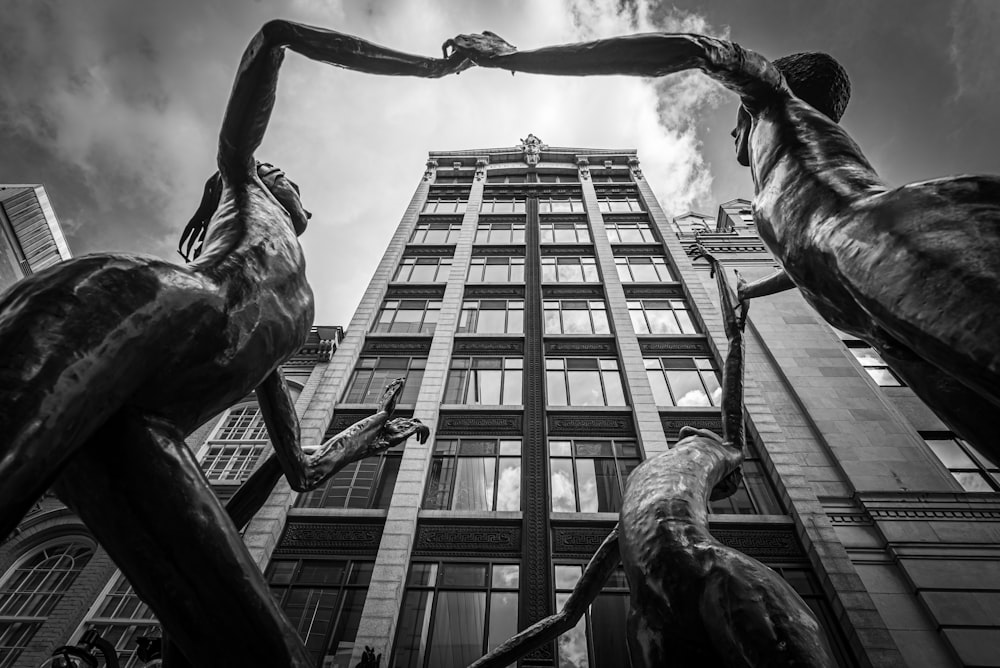 grayscale photography of statues near building