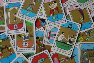 A close-up photo of colorful Marseille tarot cards spread out on a wooden table.