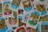 A collection of colorful tarot cards is scattered across a surface, showcasing various illustrations and symbols. Each card features unique artwork depicting figures and symbols, with labels in Spanish at the bottom. The cards are arranged haphazardly, overlapping each other.