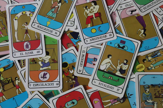 A close-up photo of colorful Marseille tarot cards spread out on a wooden table.