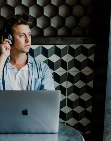 man sitting in front of silver MacBook