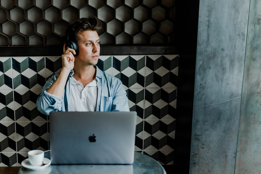 man sitting in front of silver MacBook