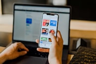 person using smartphone and laptop at the same time