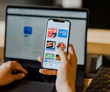 person using smartphone and laptop at the same time