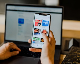 person using smartphone and laptop at the same time