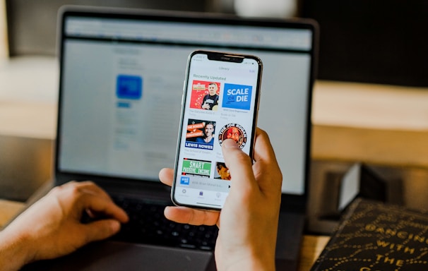 person using smartphone and laptop at the same time