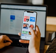 person using smartphone and laptop at the same time