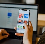 person using smartphone and laptop at the same time