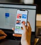 person using smartphone and laptop at the same time