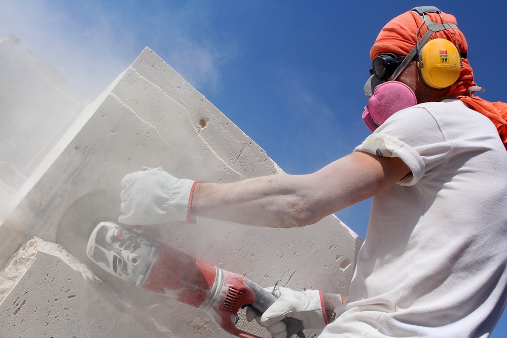 man holding angle grinder during daytime