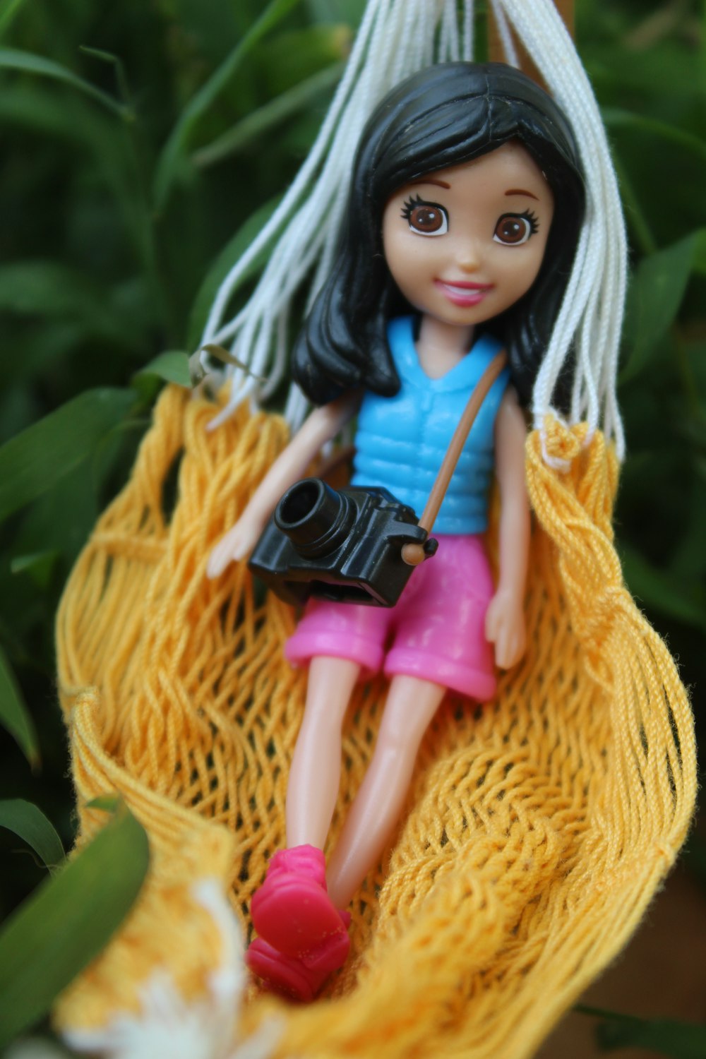 fille portant un débardeur bleu et un short poupée sur hamac