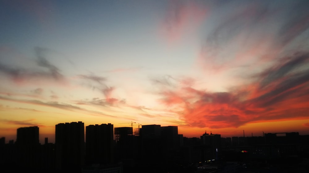 a sunset view of a city with tall buildings