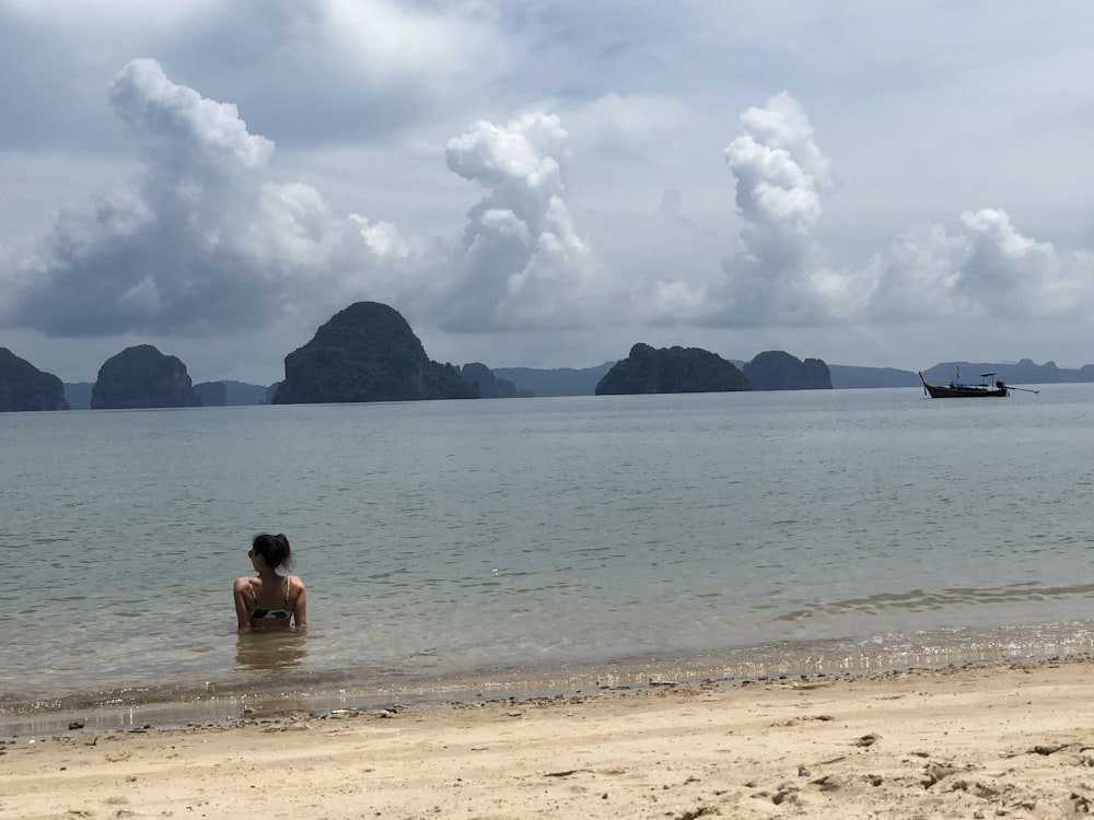 woman seated on body of water