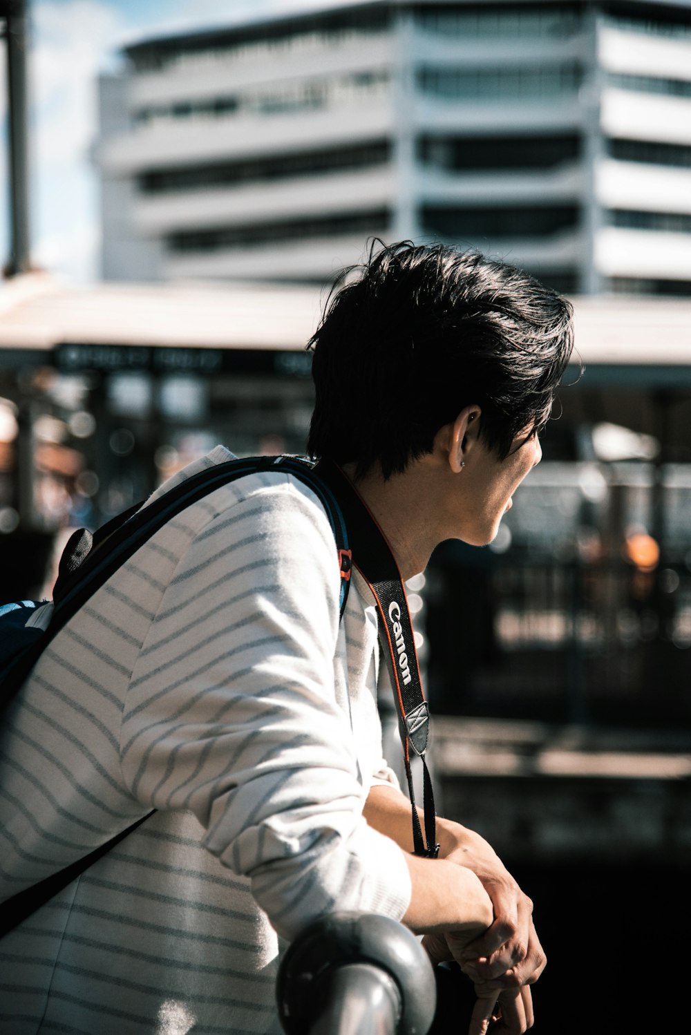 man leaning on black bar