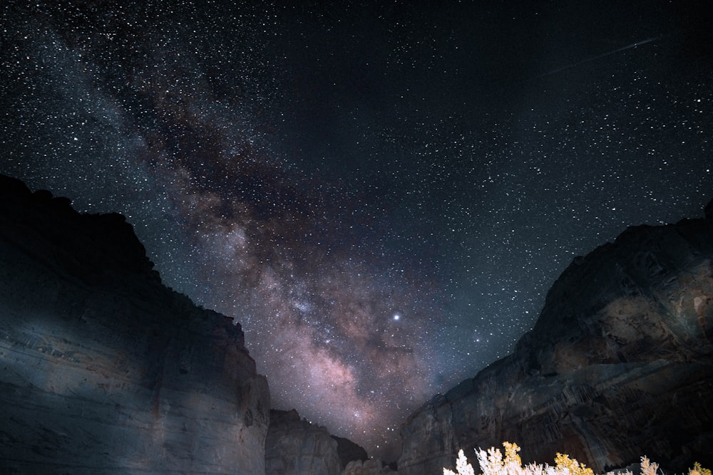 O céu noturno está cheio de estrelas acima de uma cordilheira