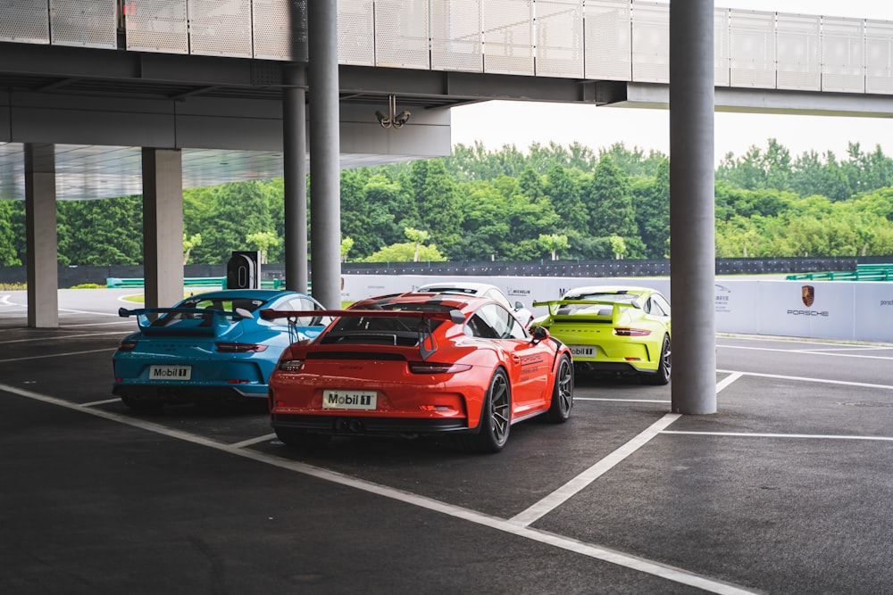 vier Porsche-Sportwagen unter Brücke geparkt