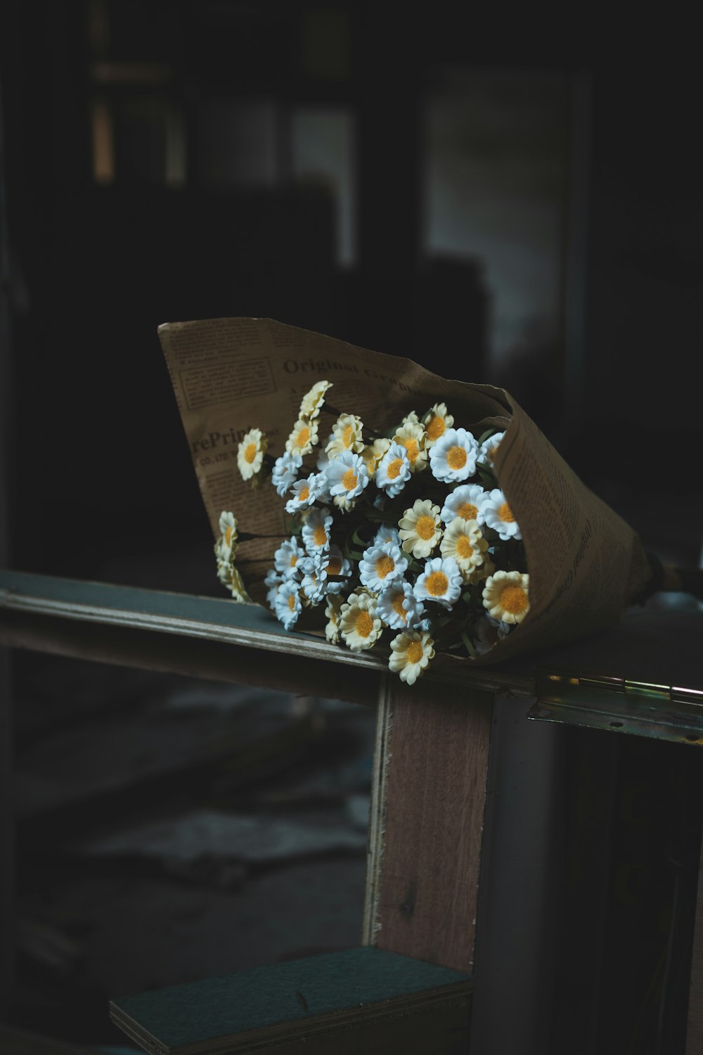 yellow and white flowers bouquet on brown wooden bench