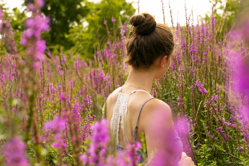 woman standing on pin flowers field