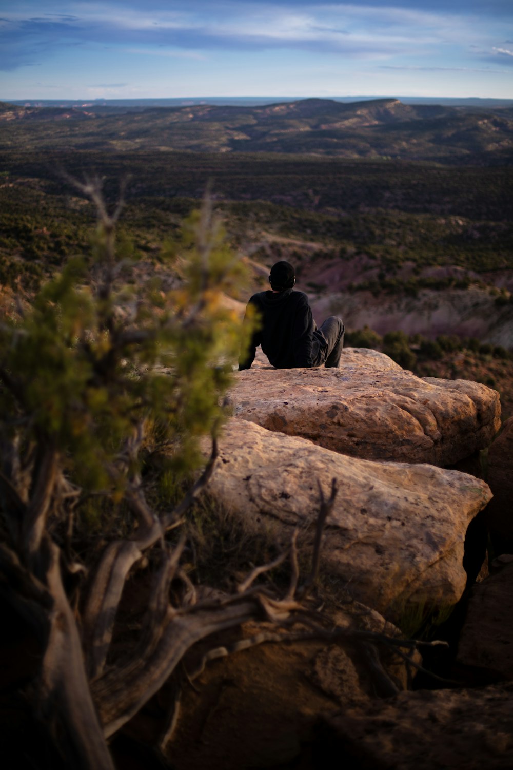 man sitting on brown mountain peak