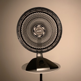 gray fan on white wooden table