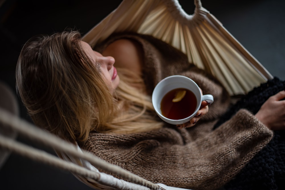 Mujer en la hamaca sosteniendo una taza de café