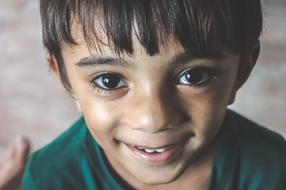 close-up photography of toddler wearing green shirt