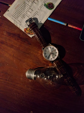 Close-up of a colorful price list displayed on a wooden table with natural light.