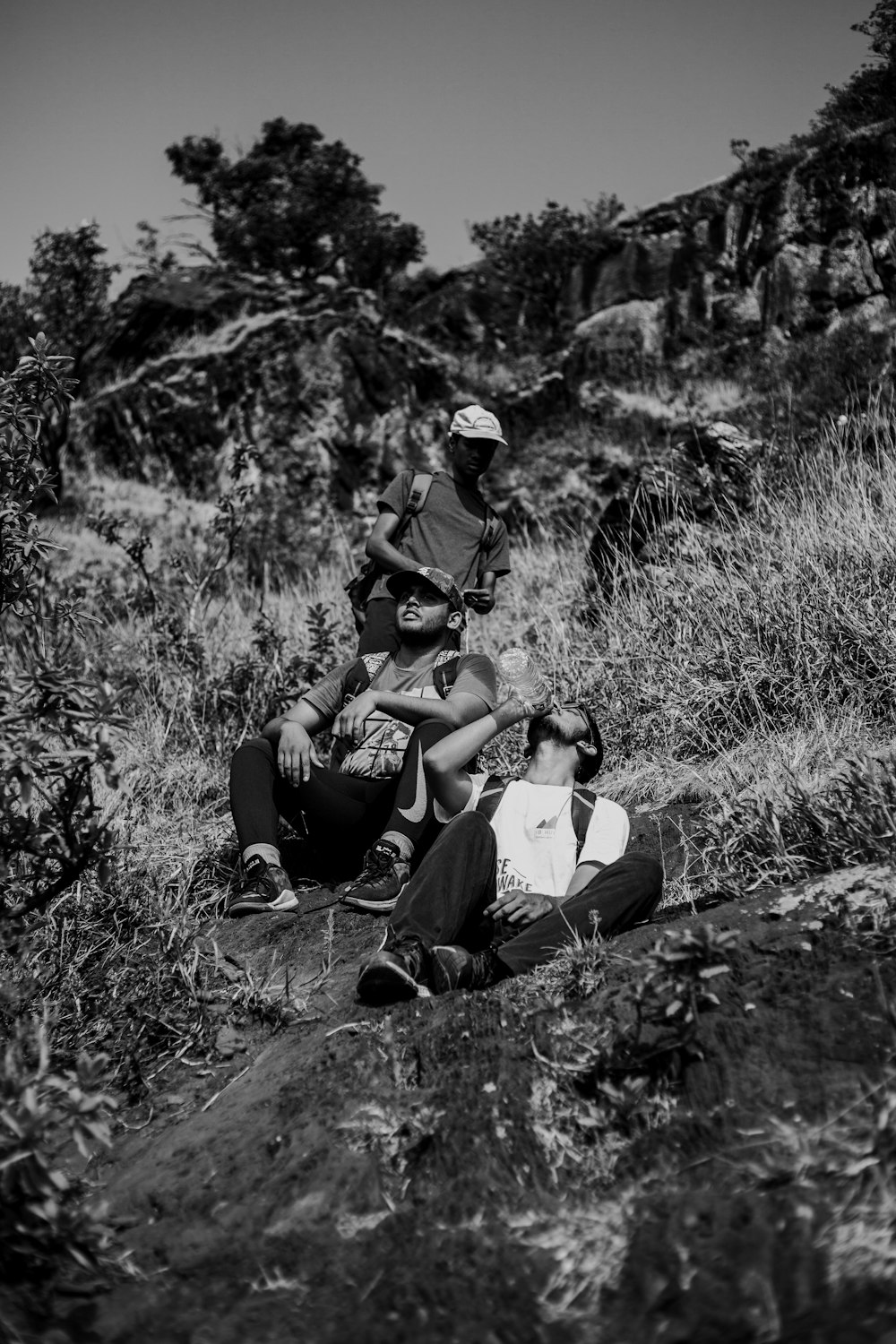 people sitting and standing on mountain hill during day