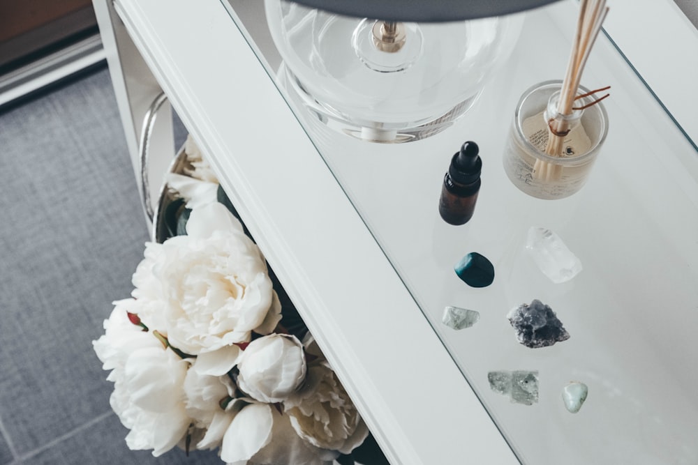 black droplet bottle beside six stones on white table