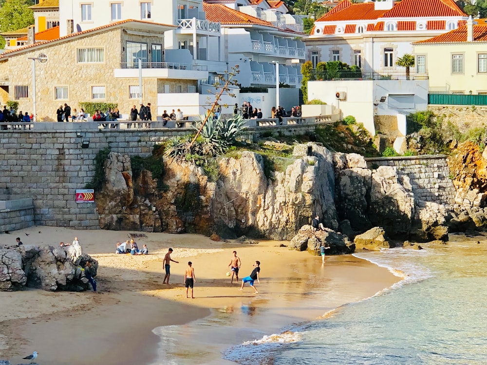 people playing on seashore near buildings