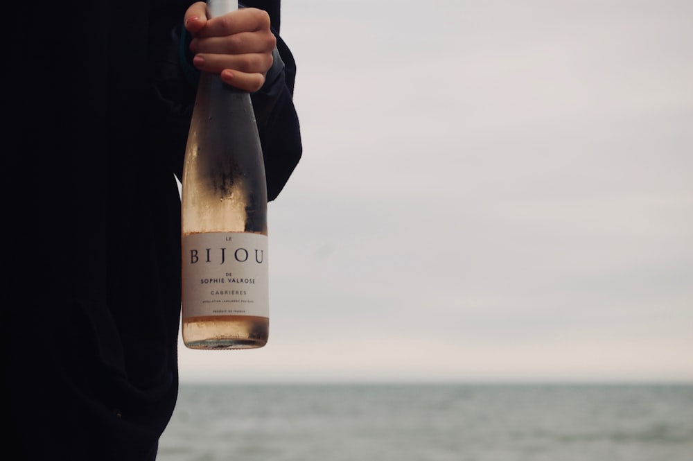 person holding bottle of Bijou white wine