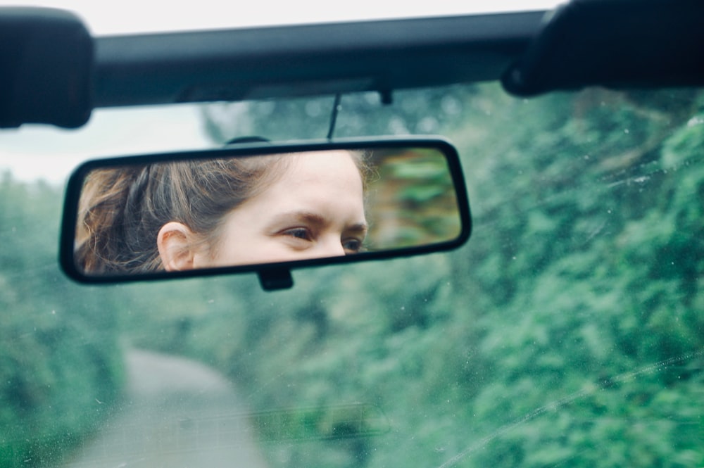 woman's face in car rear view mirror