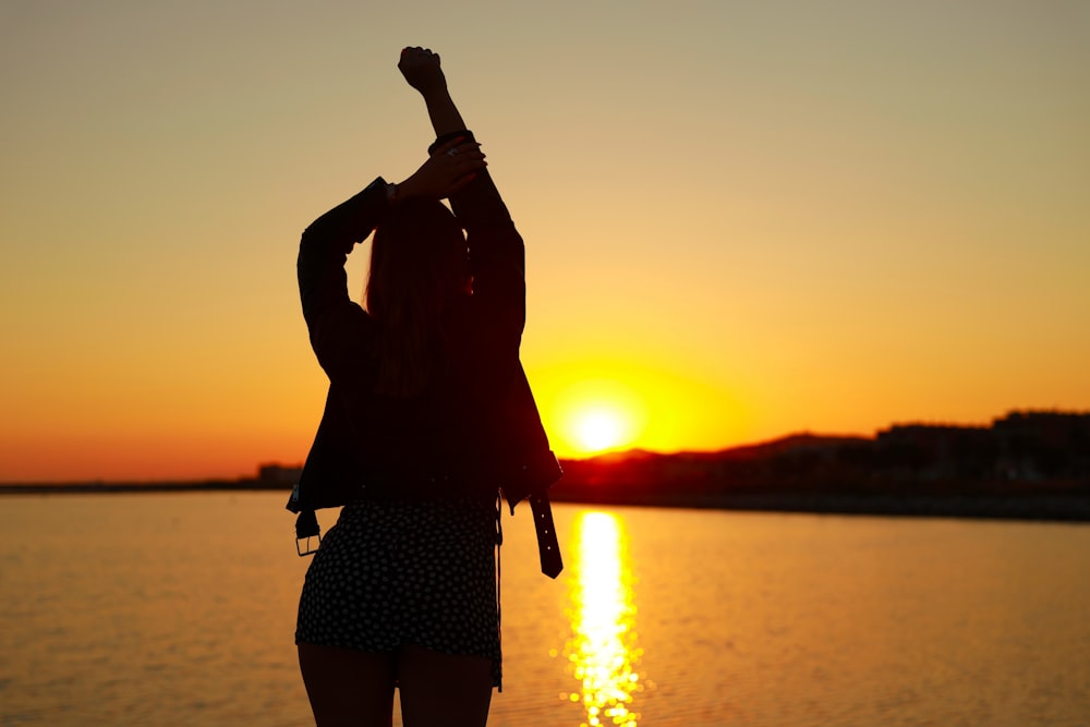 silhouette of woman standing on shore